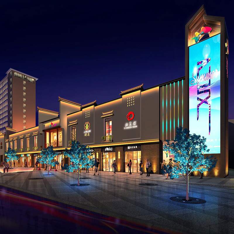 Shopping center exterior with illuminated signs and architectural lighting at night